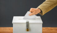 Man putting a ballot into a voting box